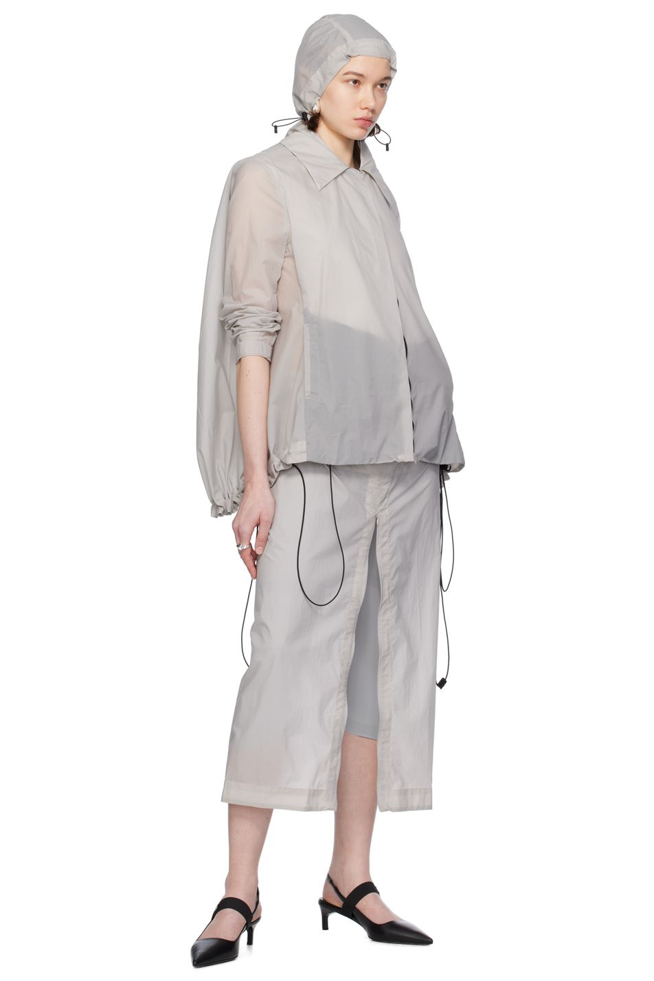 A model wears a hat, jacket, and skirt by designer Johanna Parv for SSENSE.