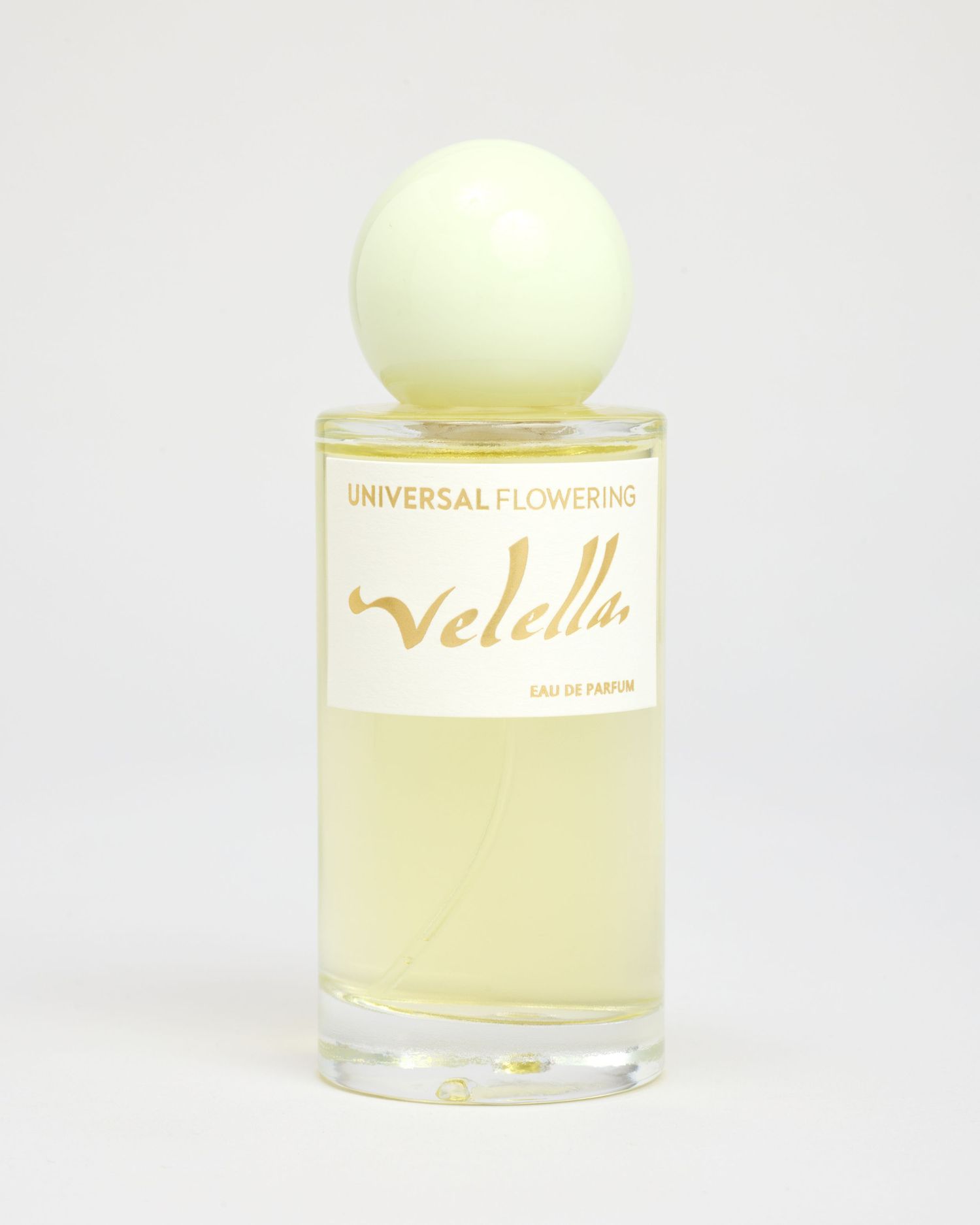 A bottle of Universal Flowering's Velella perfume sits on a light grey backdrop.