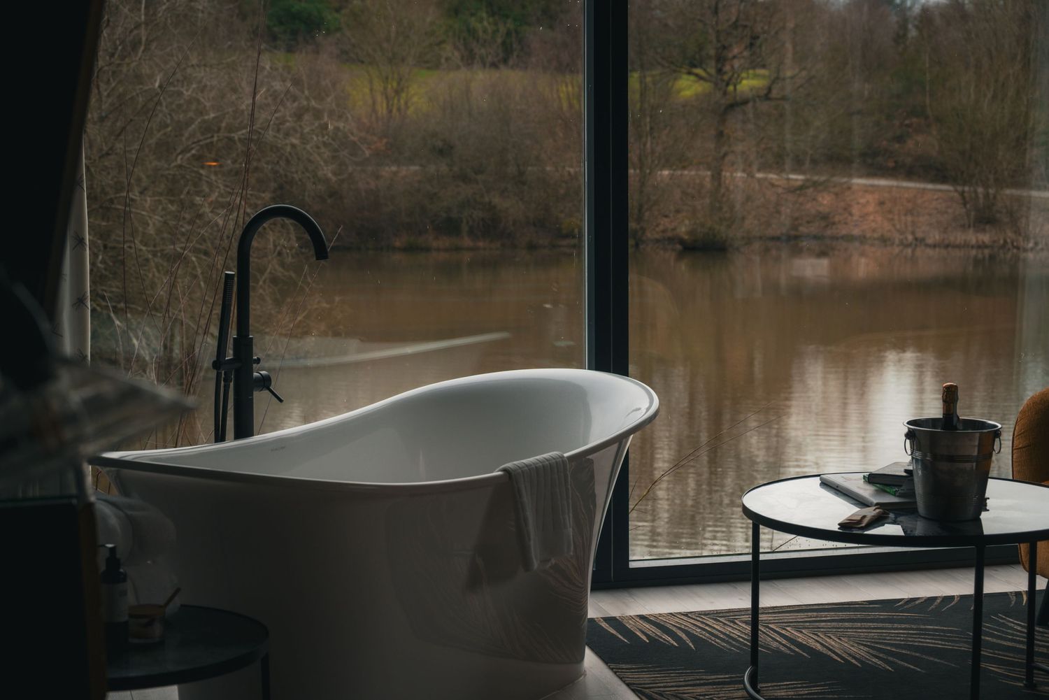 Freestanding bathtub on an outdoor deck overlooking calm water