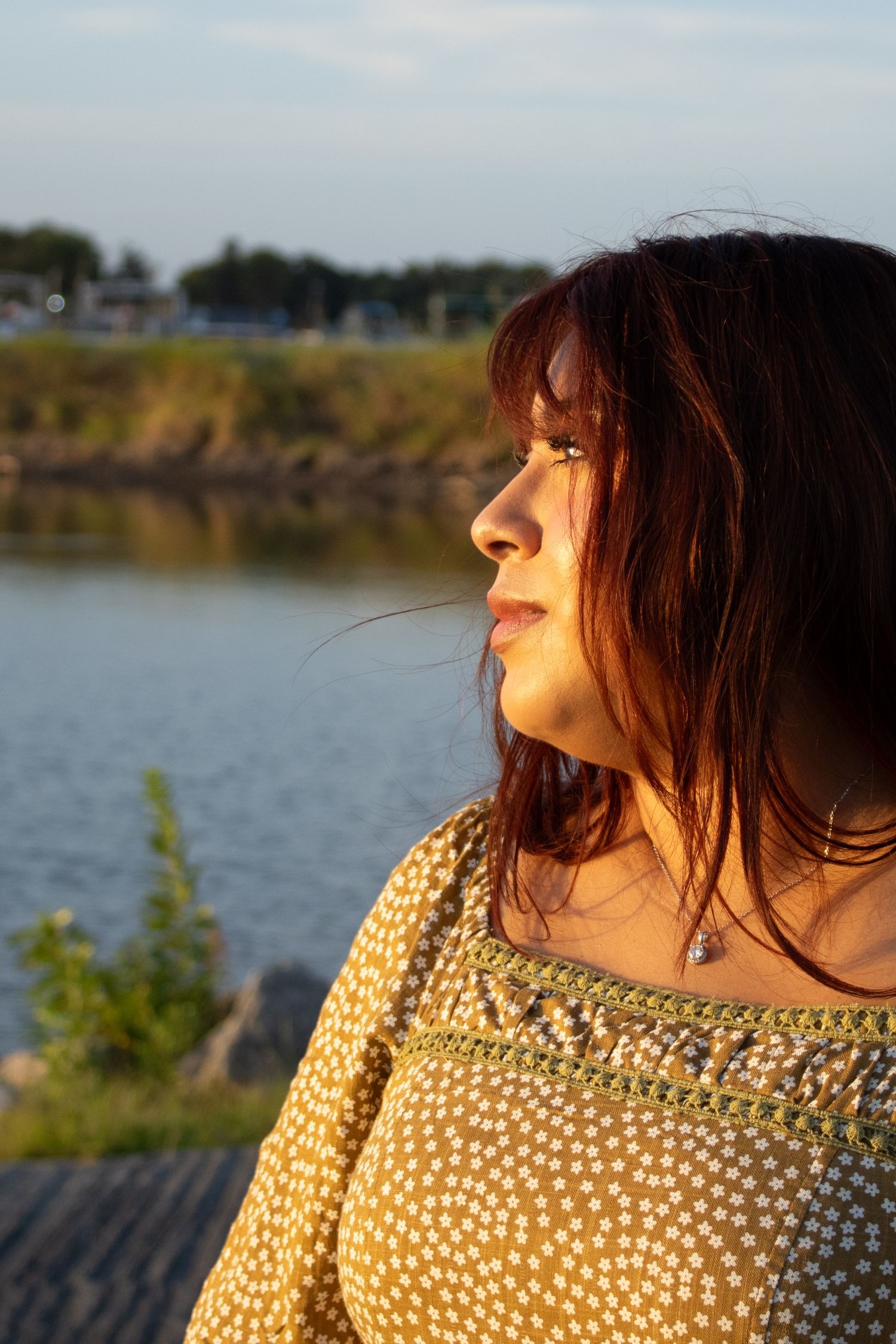 Woman in warm golden-hour light beside the water