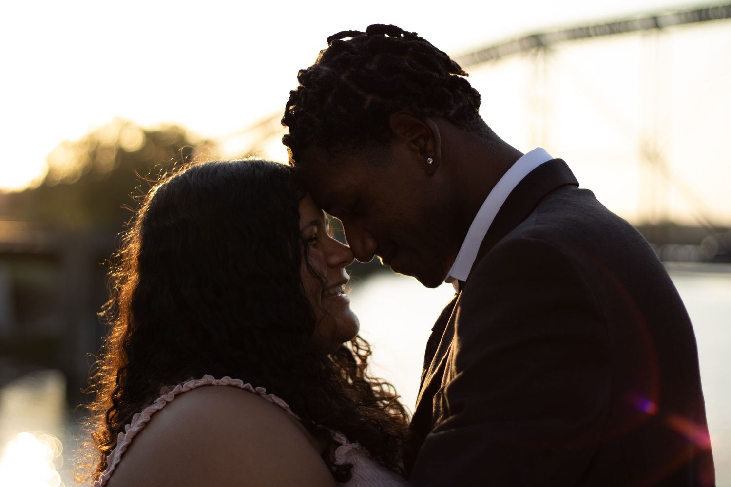 Couple sharing an intimate moment by the water at golden hour