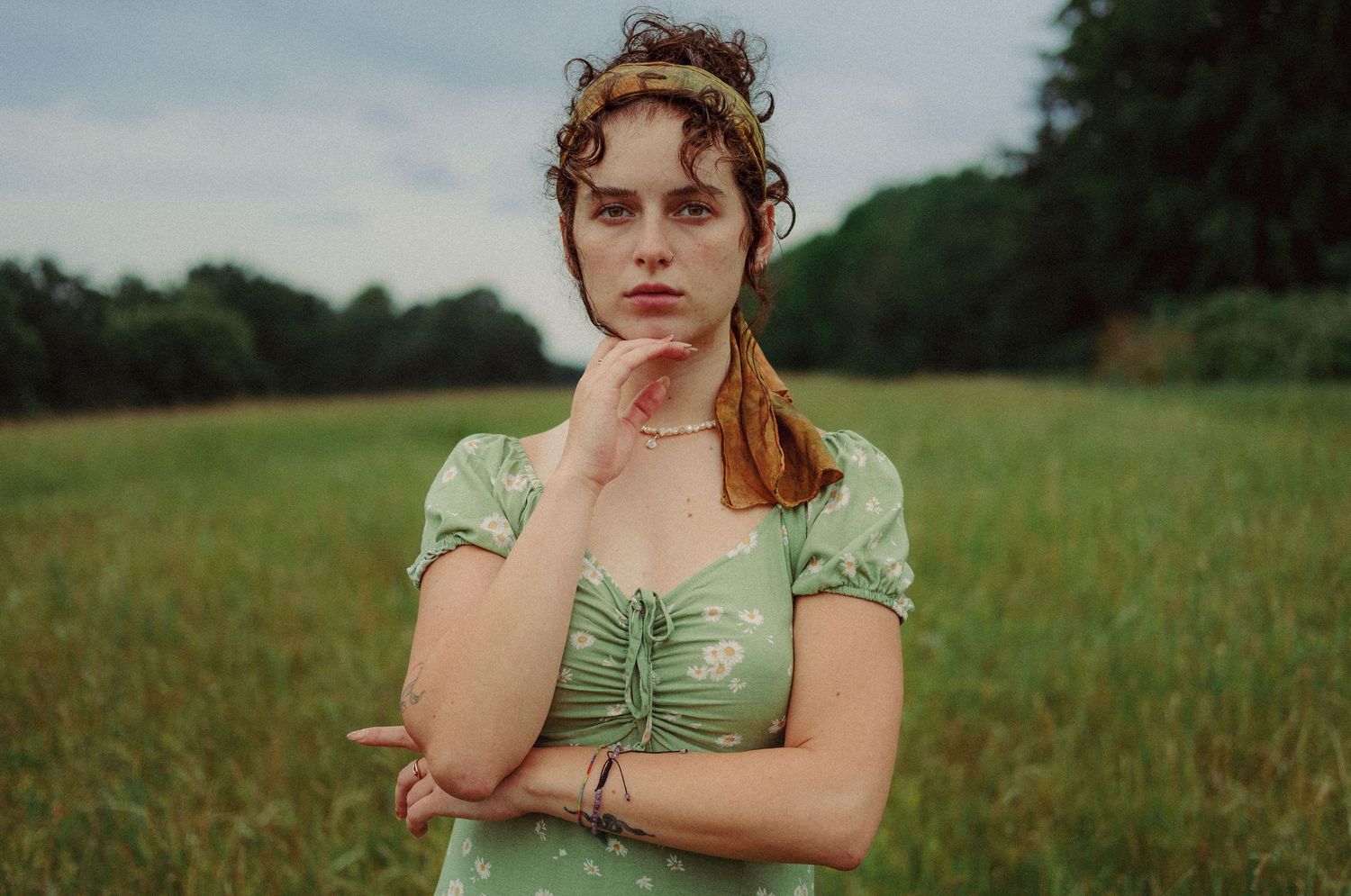 Cinematic portrait of a woman standing in a green field