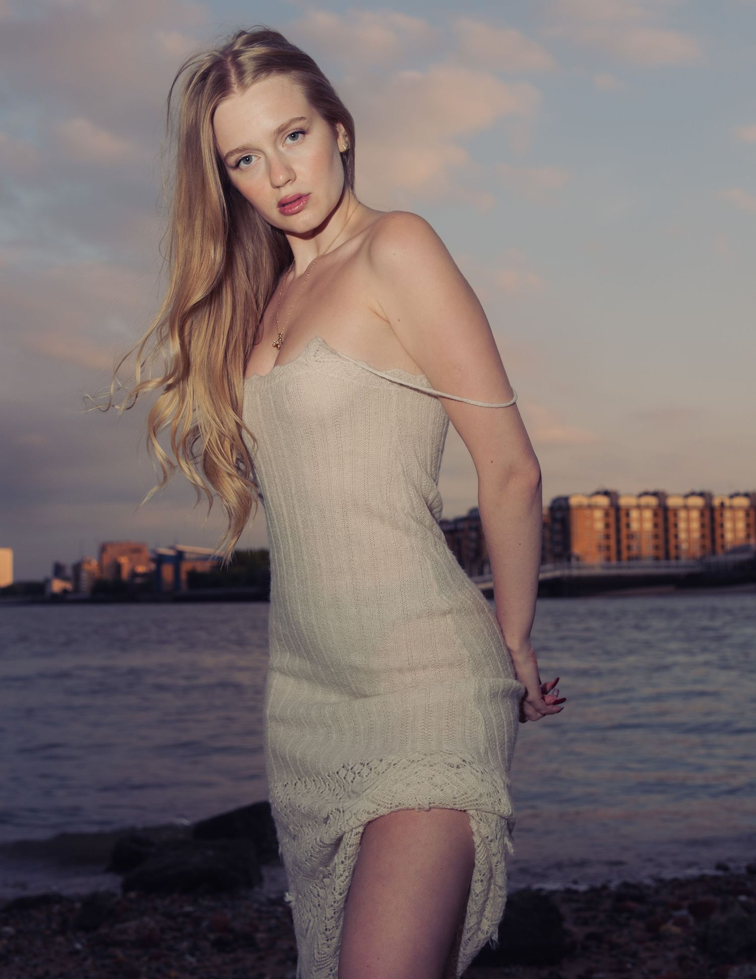 Cinematic outdoor portrait of a woman beside the water at sunset