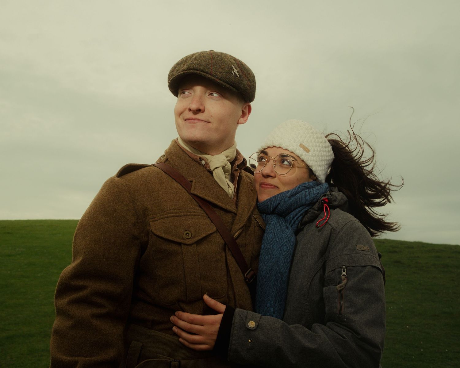Portrait of a couple in vintage clothing standing together in a field