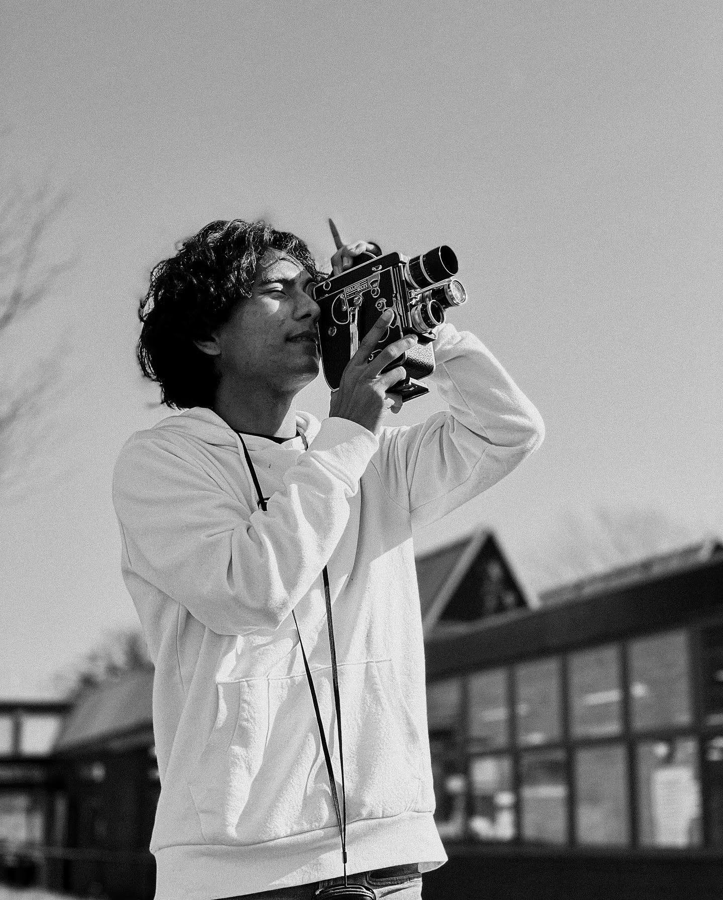 A guy using a vintage film camera - Bolex camera