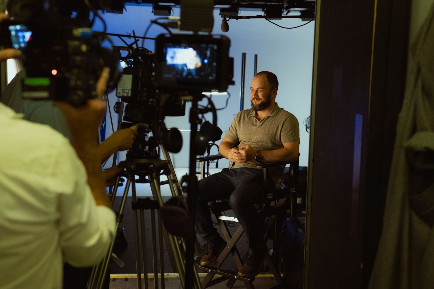 Behind-the-scenes photograph of a professional interview film shoot with cinema cameras and production equipment.