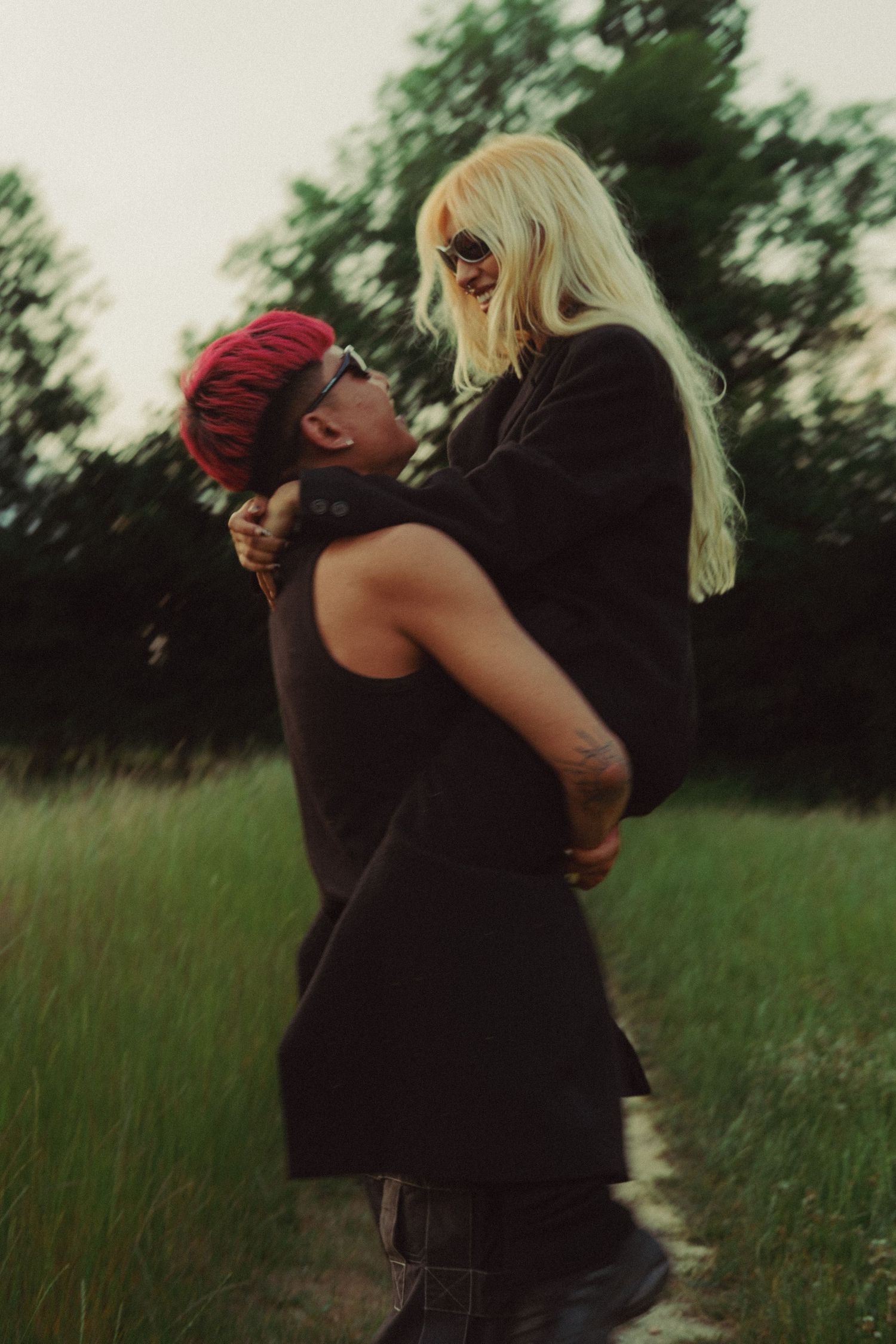 Couple embracing playfully outdoors during a romantic pre-wedding photoshoot