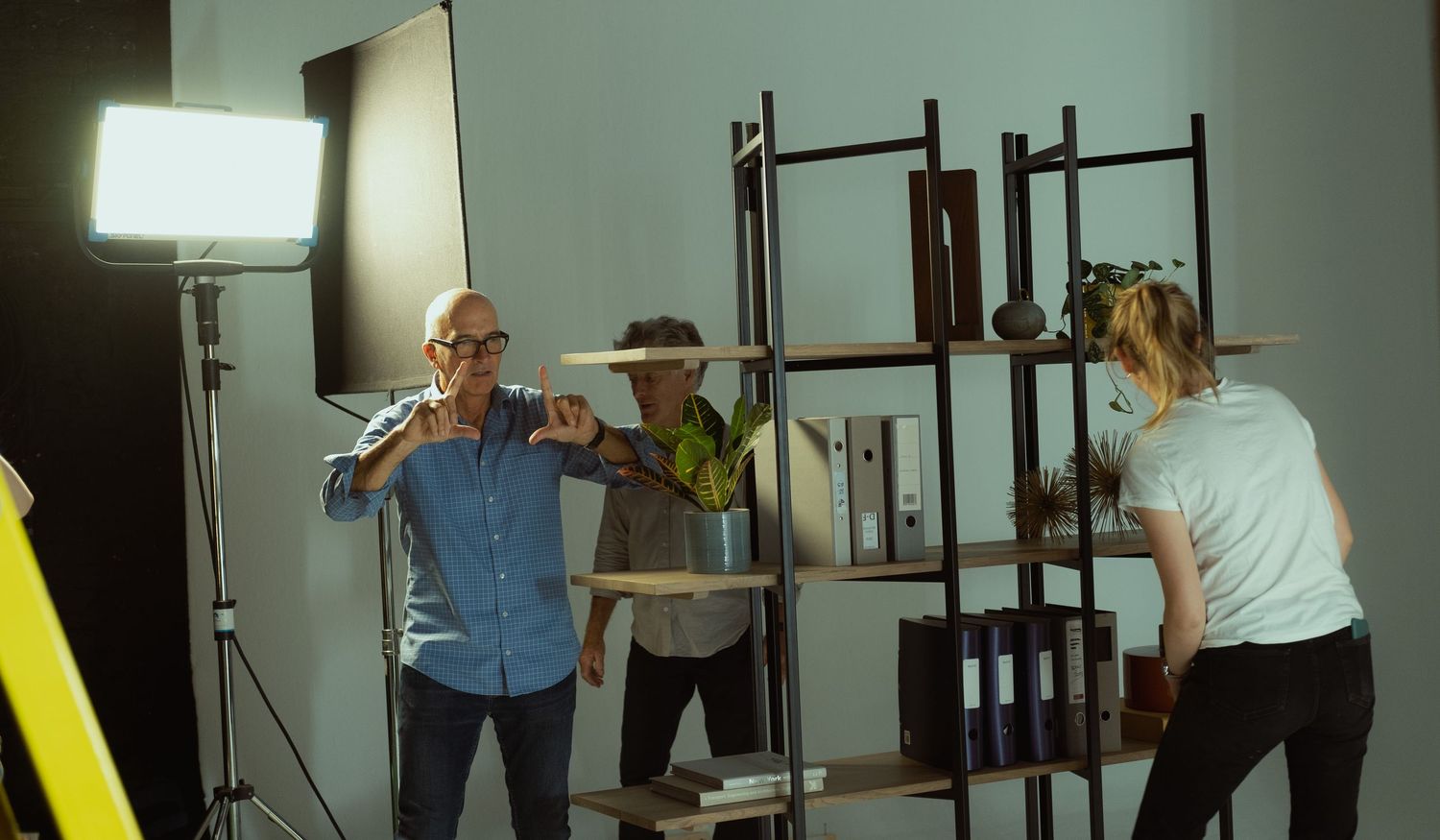 Behind-the-scenes photograph of a commercial film shoot with actors, lighting and production equipment on set.