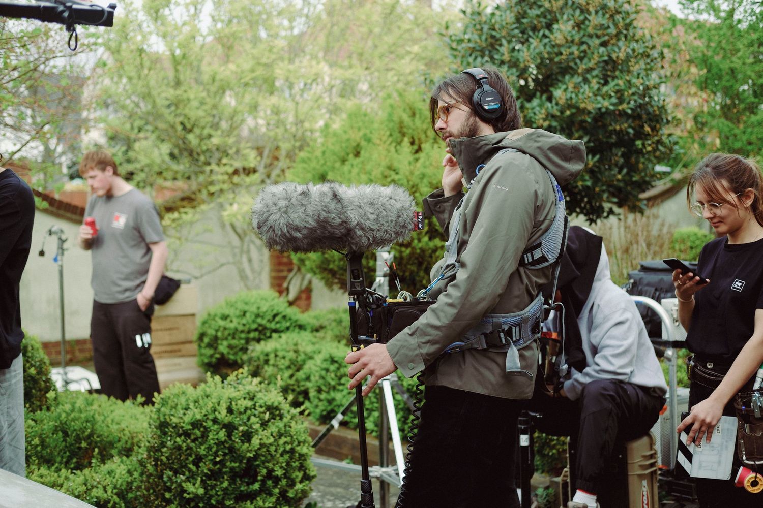Behind-the-scenes BTS photograph of a sound recordist working on location during a professional film production.
