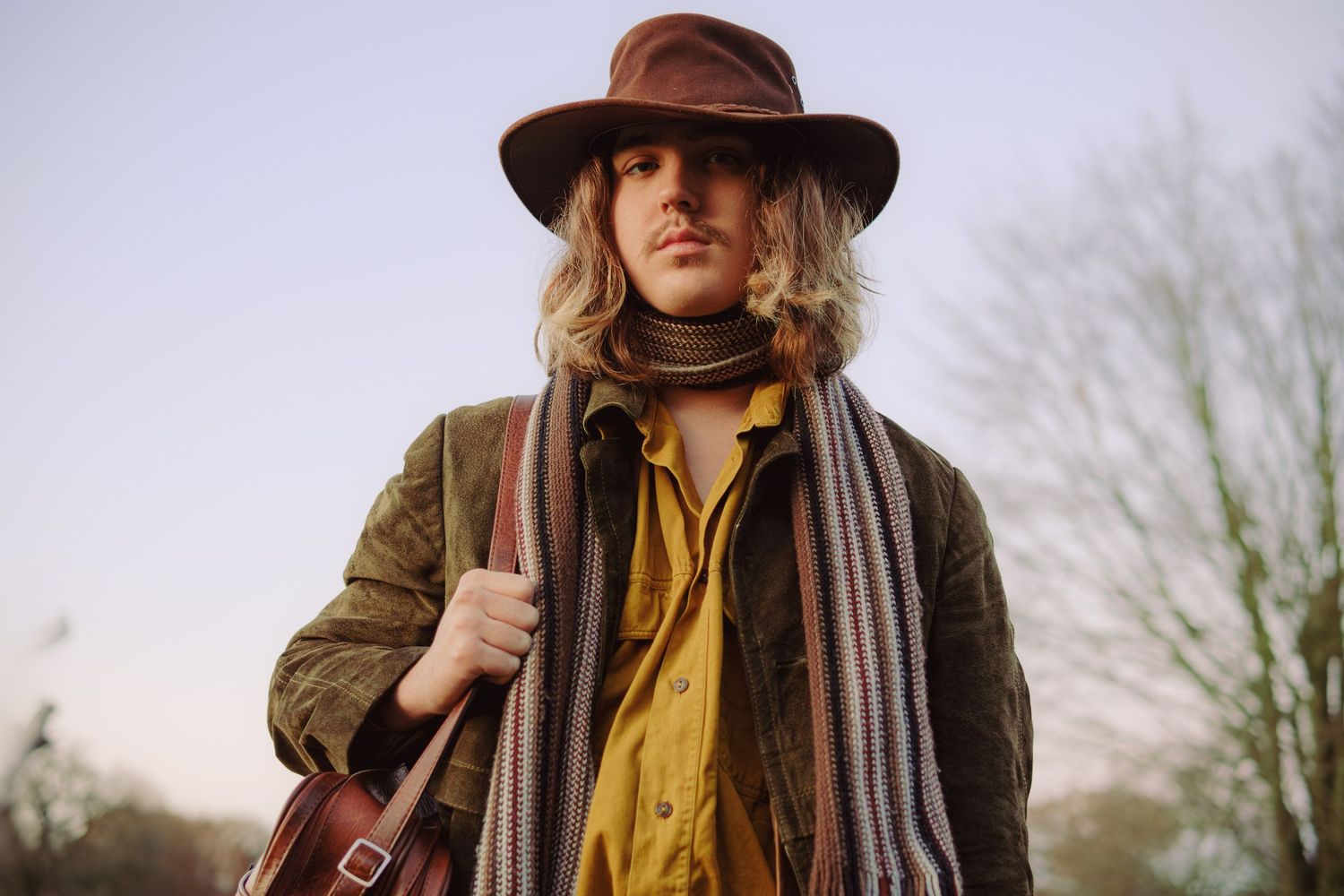 Cinematic portrait of a man wearing a hat and scarf outdoors