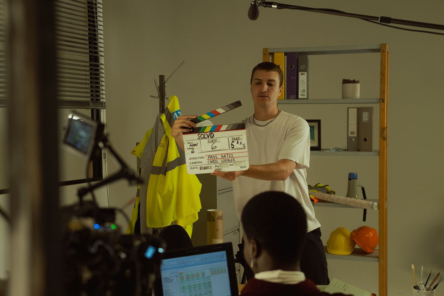 Behind-the-scenes photograph of a film crew preparing a scene on set with a professional cinema camera.