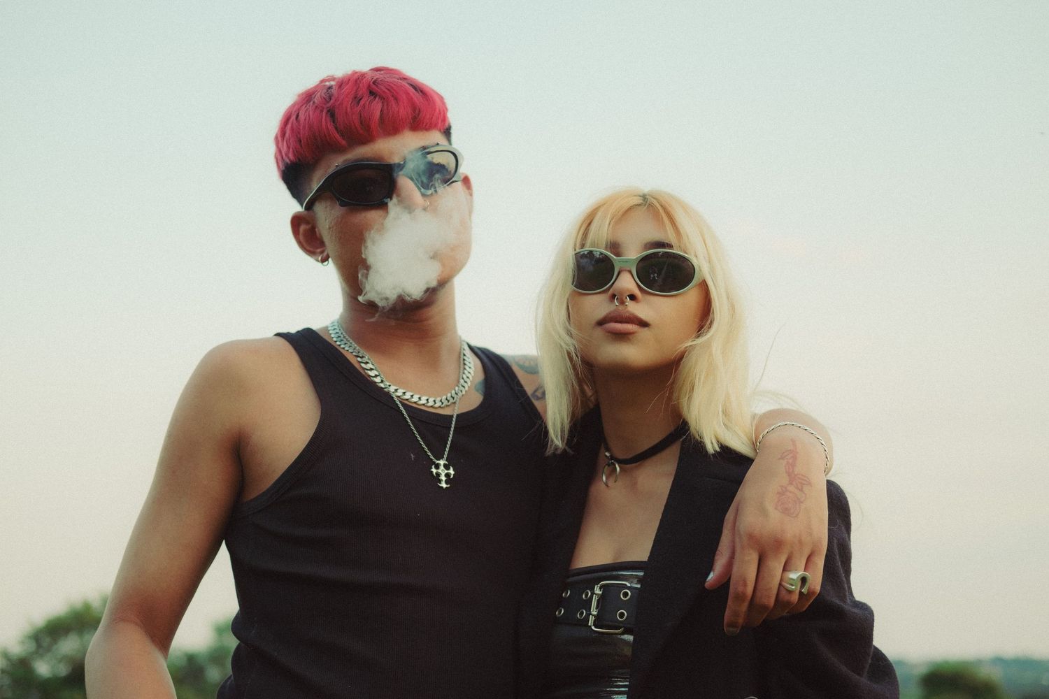Relaxed couples portrait of a stylish couple standing together outdoors, captured in a natural cinematic style. Smoking