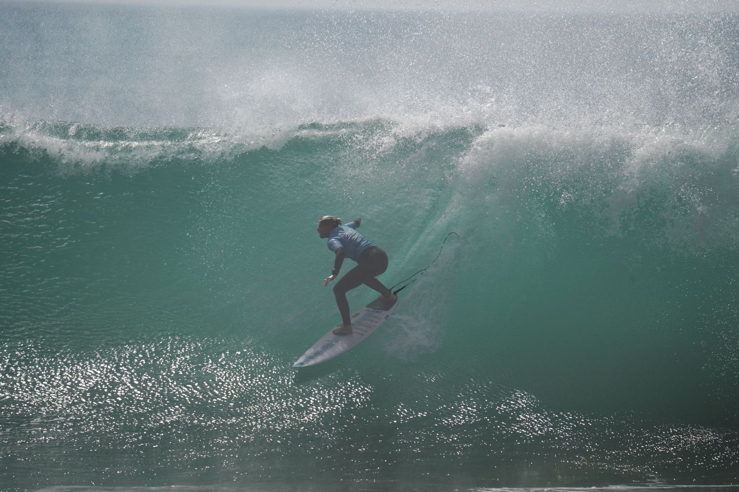 Surfer riding inside a powerful breaking wave at a competitive surfing event.