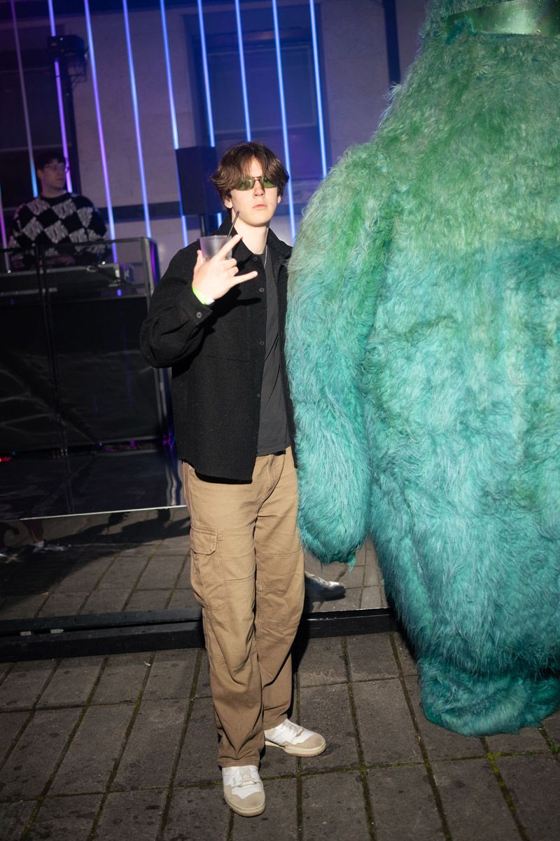Guest posing in the neon-lit Evoverse 2077 event space
