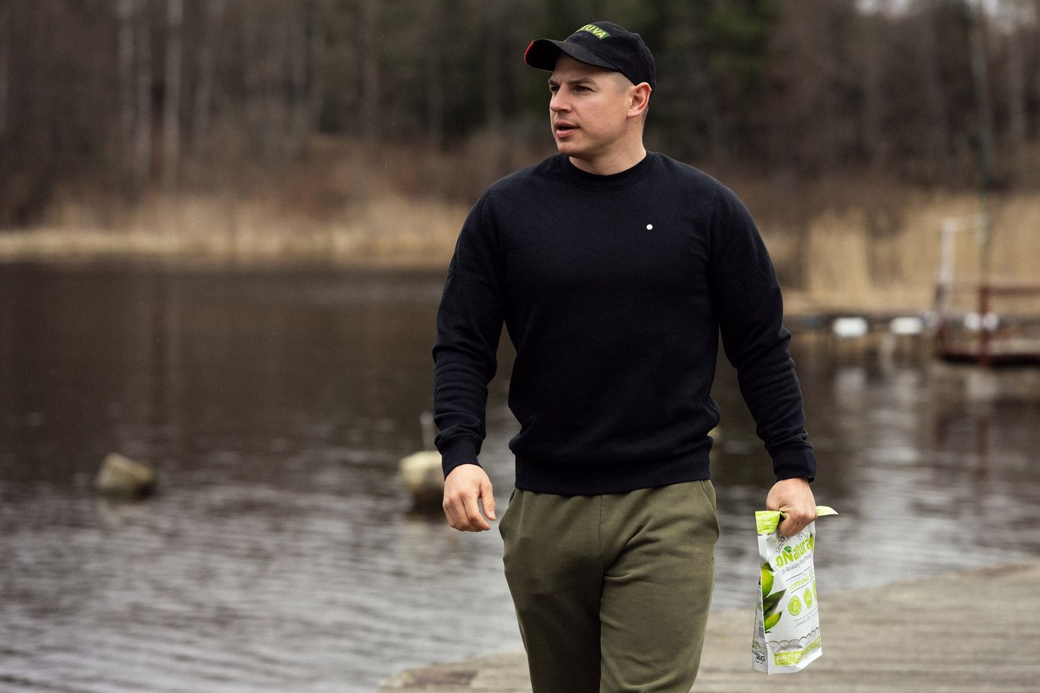 Aurimas Valujavičius standing by riverside in kayaking gear, preparing for trip