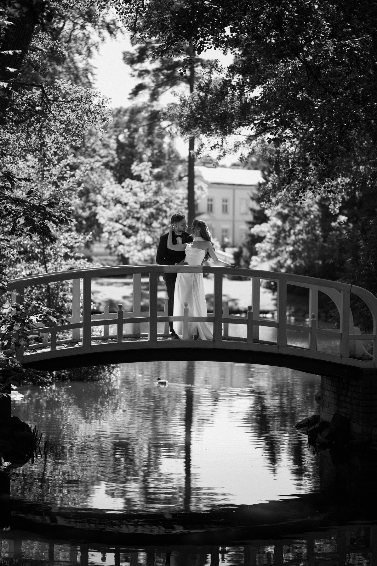 Bride and groom standing on a bridge in Birutė’s Park