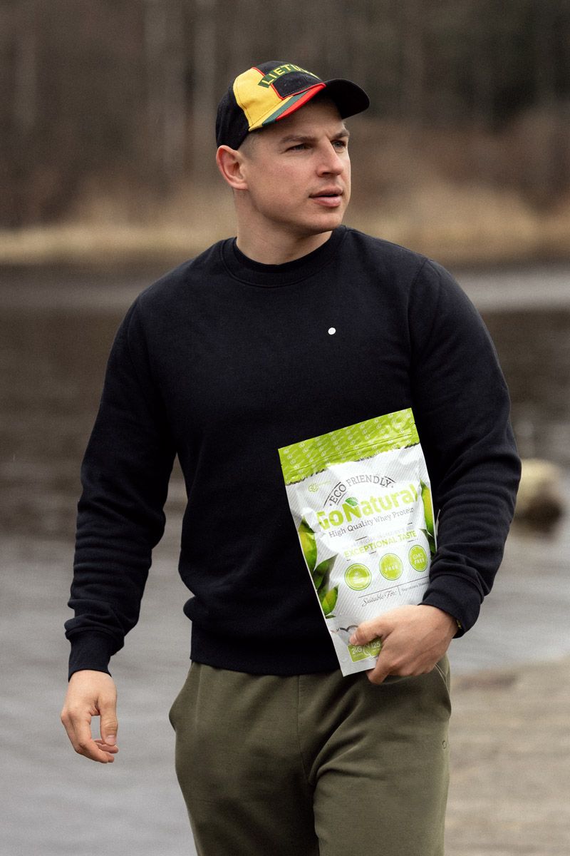 Aurimas Valujavičius in cap looking to the side, packing Rawpoders supplements for kayaking trip