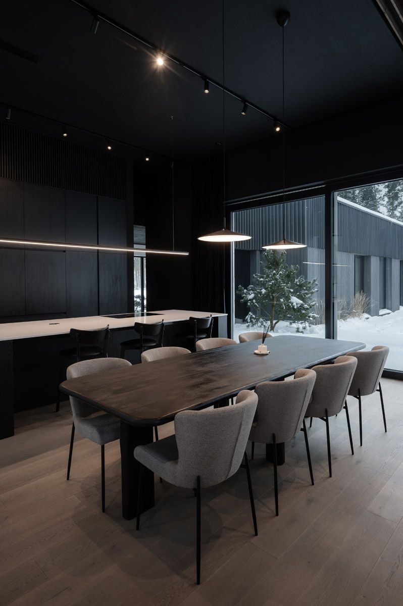 Modern dining area with dark timber ceiling and large windows