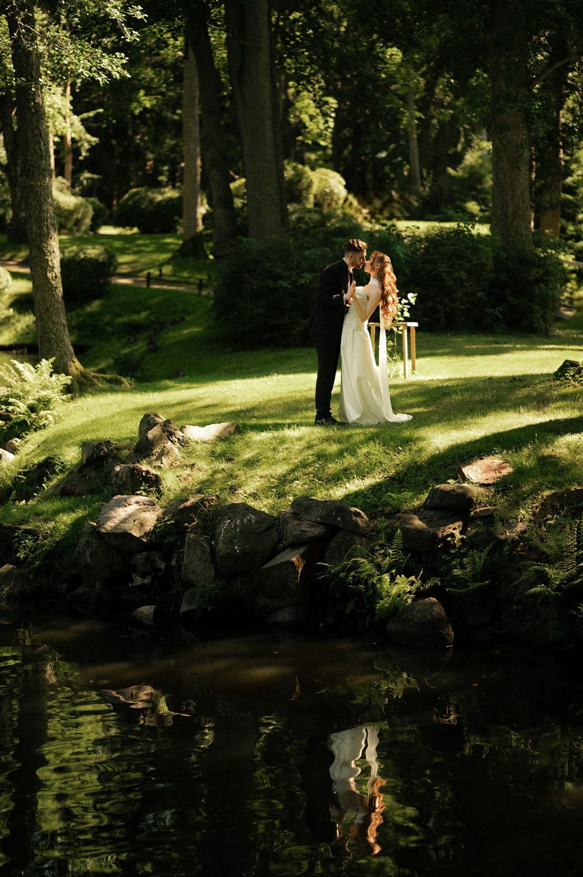 Bride and groom walking together through the park