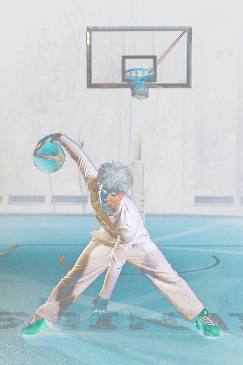 Basketball player spinning with ball against plain backdrop, motion sports photography