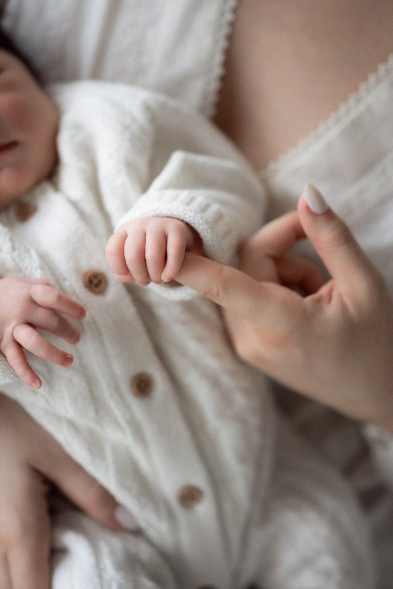 Close-up of newborn baby's tiny fingers and hand, studio newborn photography
