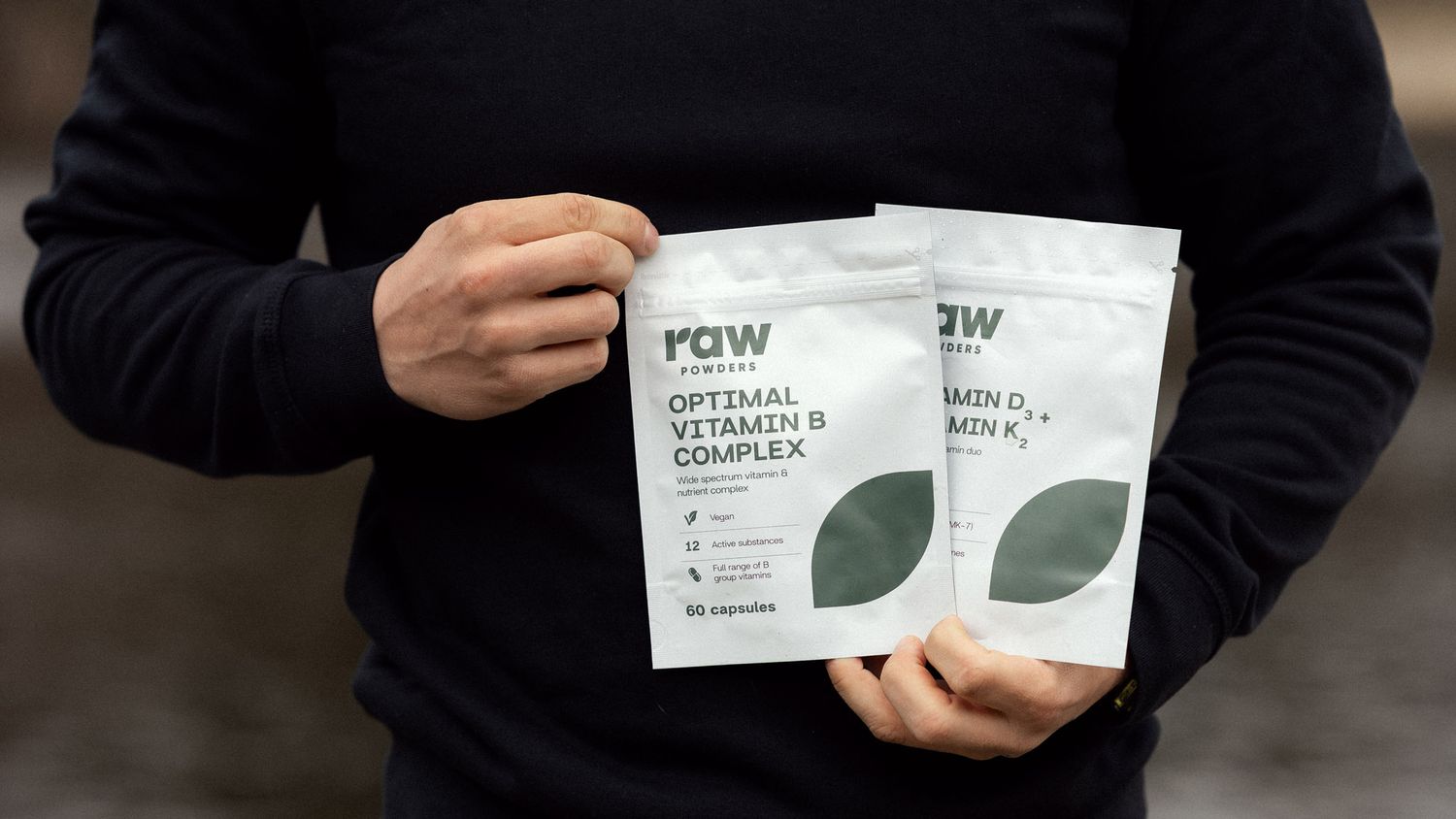 Man holding Rawpoders vitamin B complex supplement while preparing for kayaking trip
