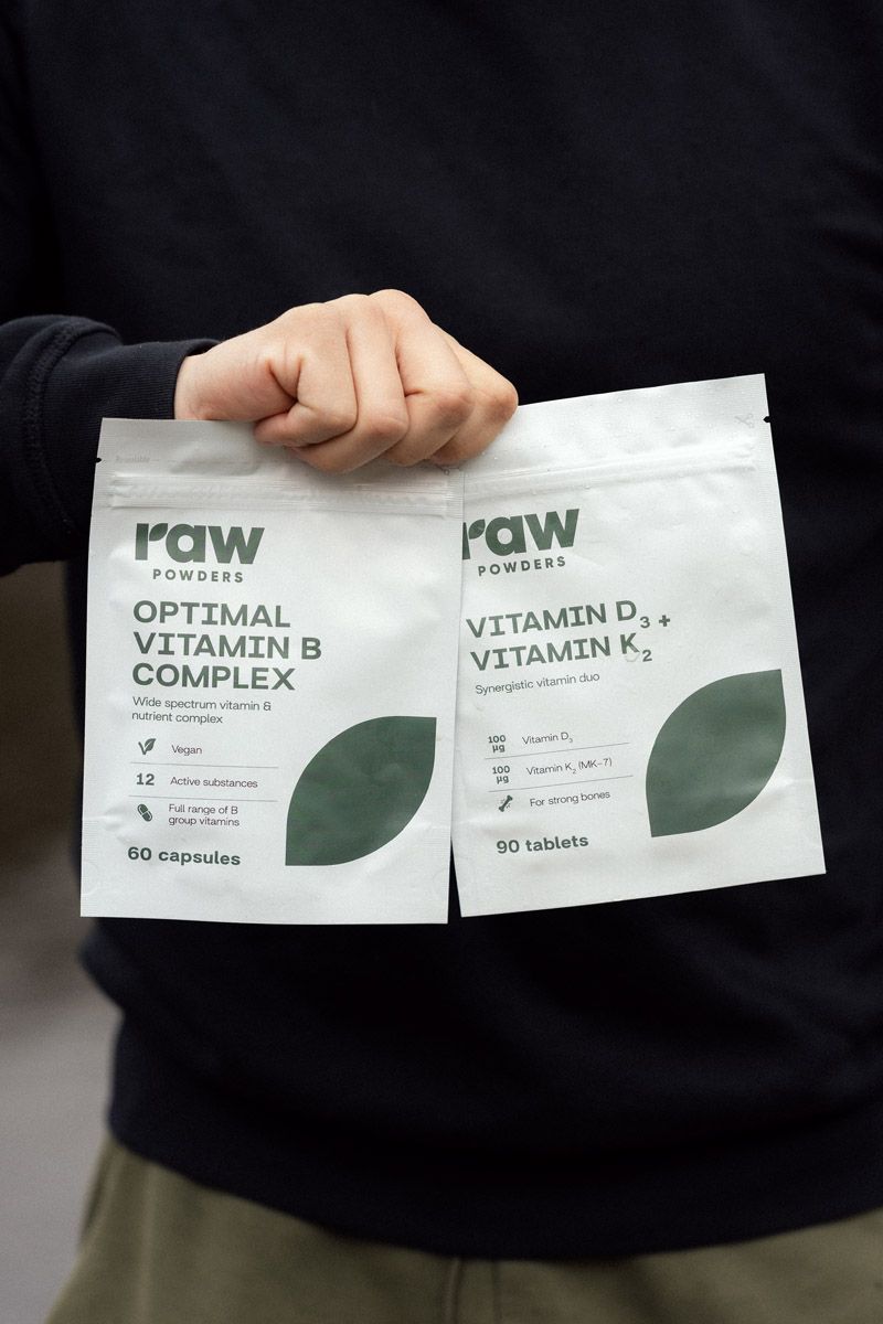 Aurimas Valujavičius holding Rawpoders vitamin D and vitamin K supplement packets before kayak trip