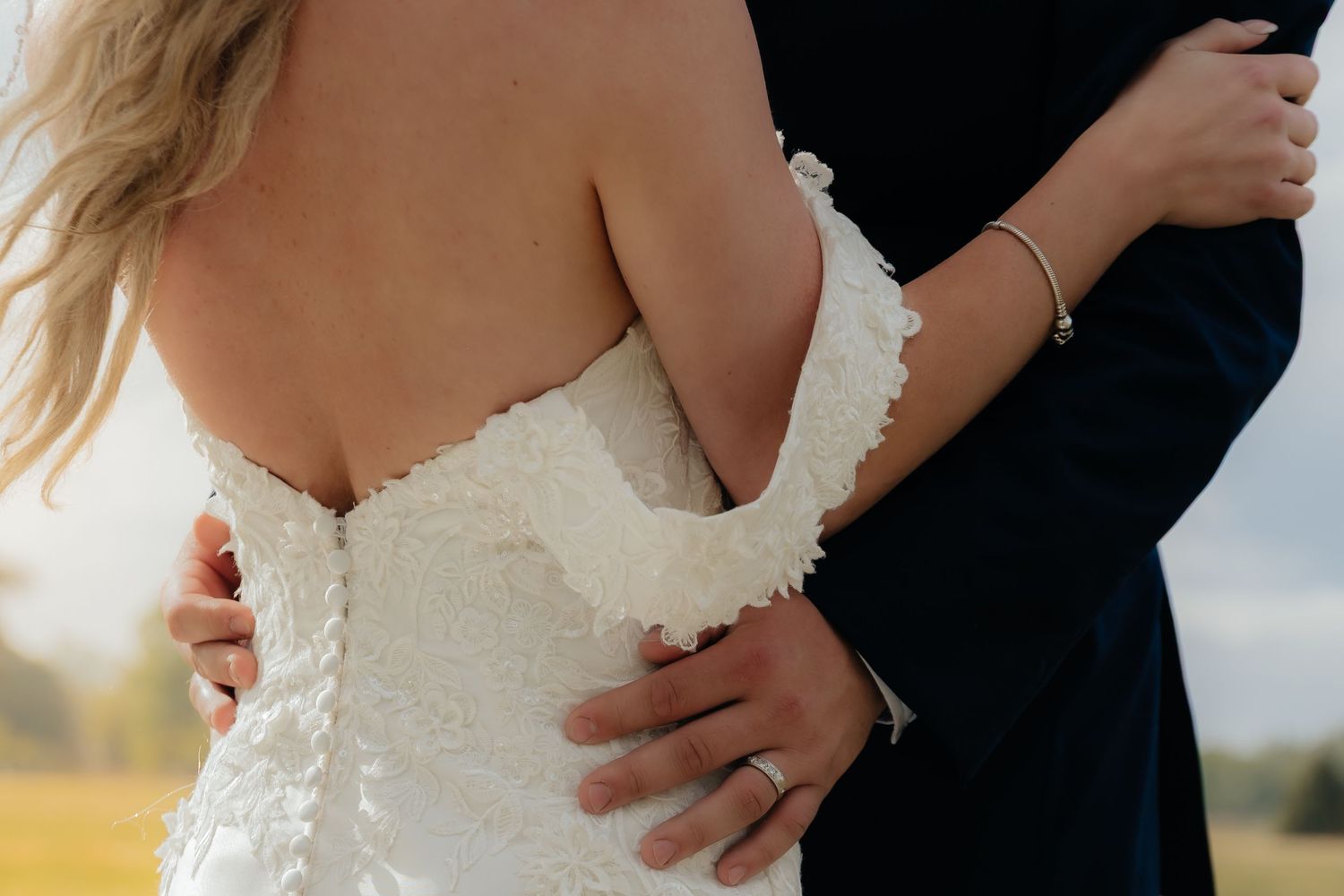 Western Nebraska Wedding Bride in white lace strapless gown embraced by groom in dark suit at golden hour