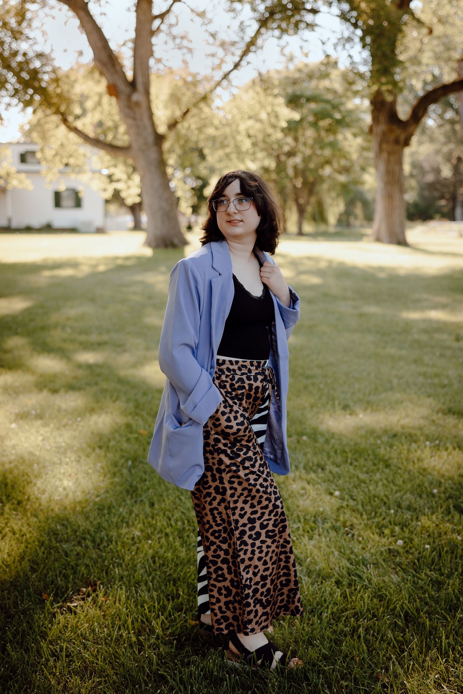 North Platte Nebraska Senior Session girl in purple blazer and animal print pants standing outdoors in a park setting.