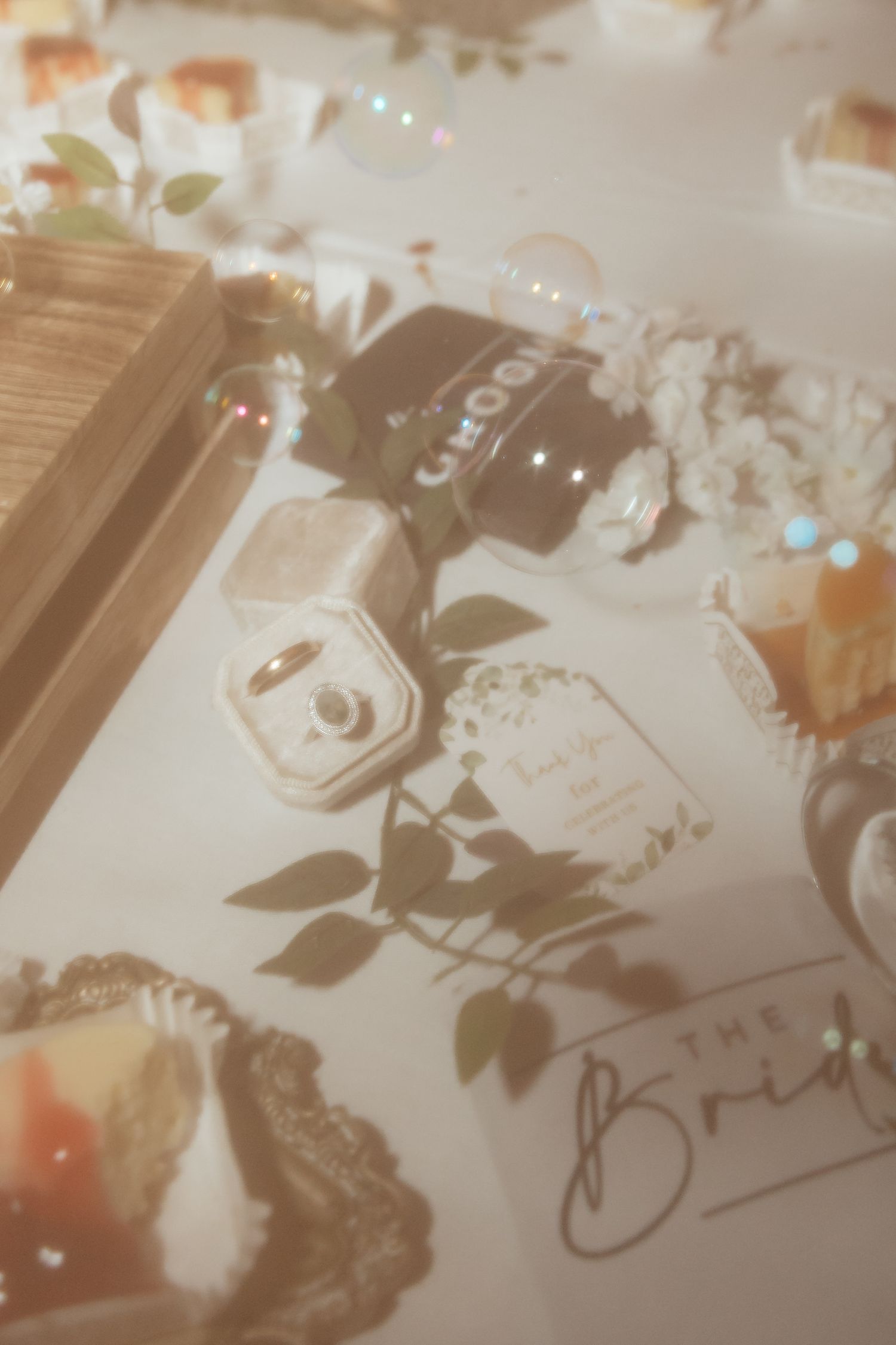 Western Nebraska Wedding flat lay with ring box, floral decor, and bridal signage on white table.