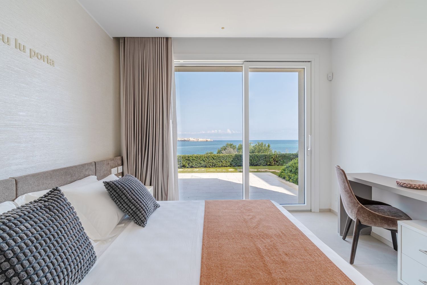 Elegante camera da letto di una villa, con arredamento sofisticato e atmosfera luminosa e rilassante.