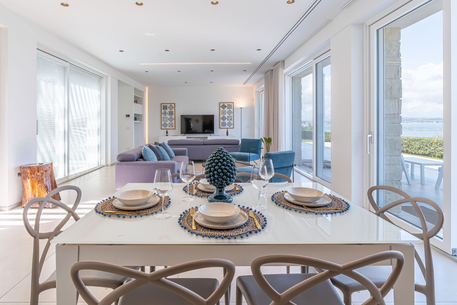 Elegante soggiorno di una villa di lusso a Siracusa con arredi raffinati e ampie vetrate