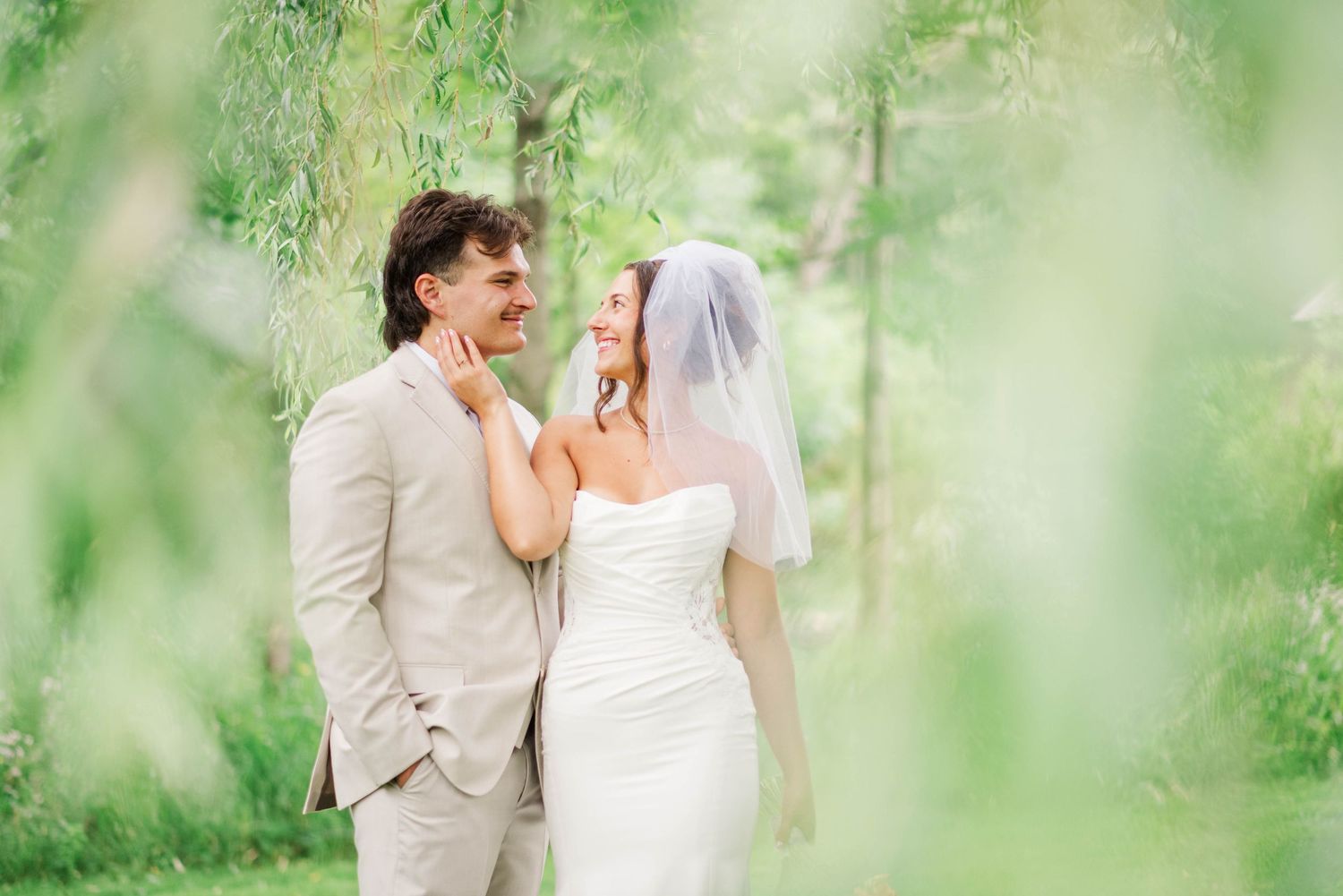 Bride and groom under willow tree at Whispering Hollow Estates in Pleasantville, Pennsylvania
