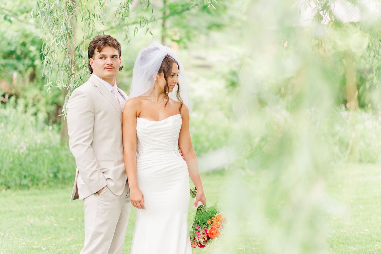Bride and groom under willow tree at Whispering Hollow Estates in Pleasantville, Pennsylvania