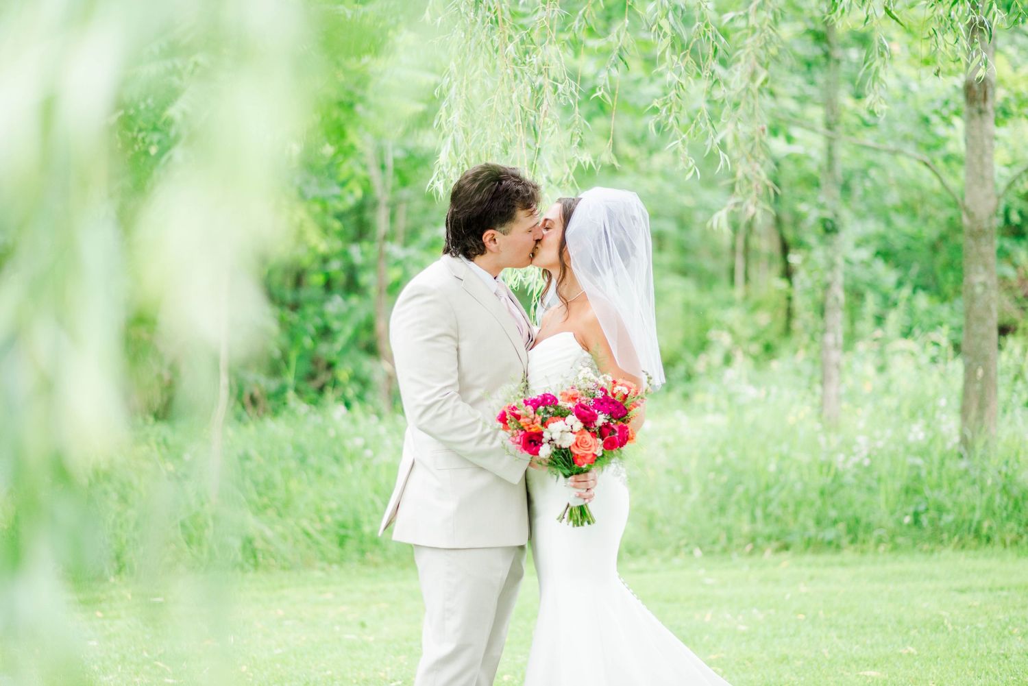 Bride and groom under willow tree at Whispering Hollow Estates in Pleasantville, Pennsylvania
