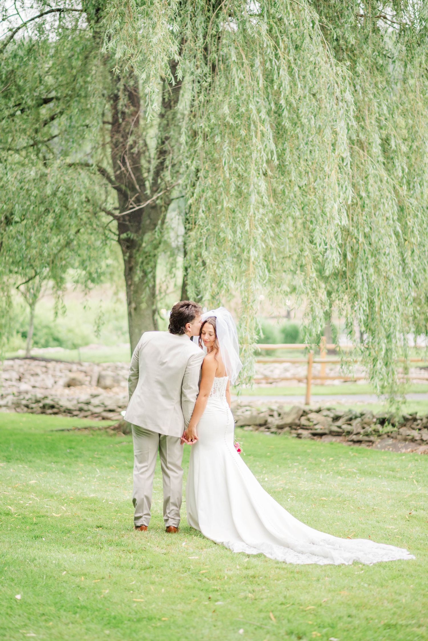 Bride and groom under willow tree at Whispering Hollow Estates in Pleasantville, Pennsylvania