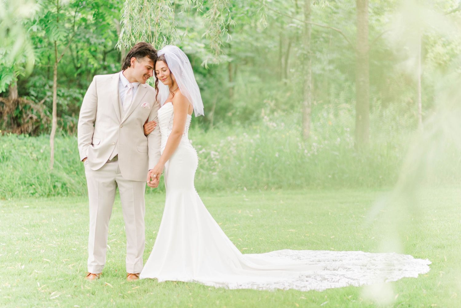 Bride and groom under willow tree at Whispering Hollow Estates in Pleasantville, Pennsylvania