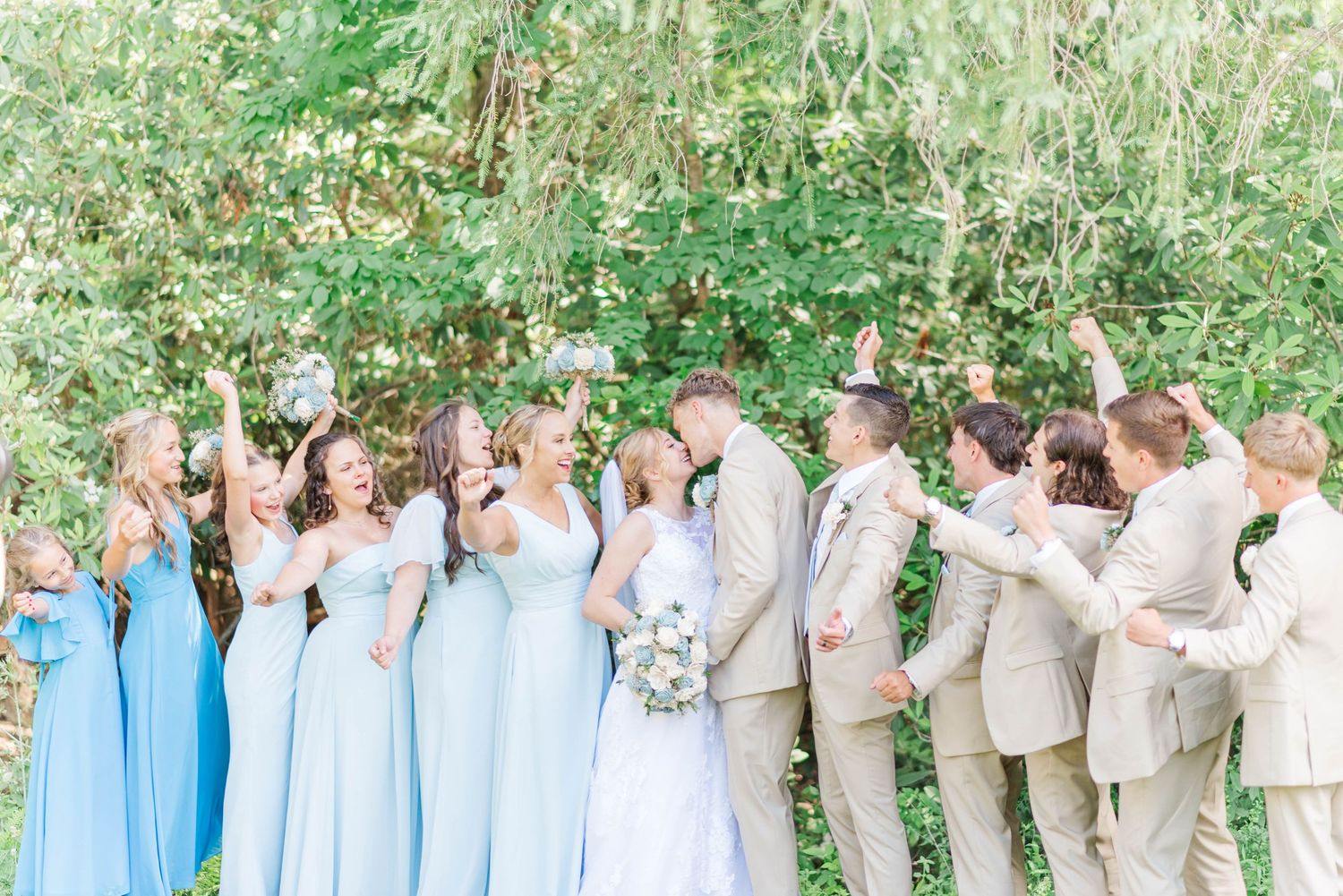 Bride and groom kiss with bridal party cheering in Ligonier, Pennsylvania
