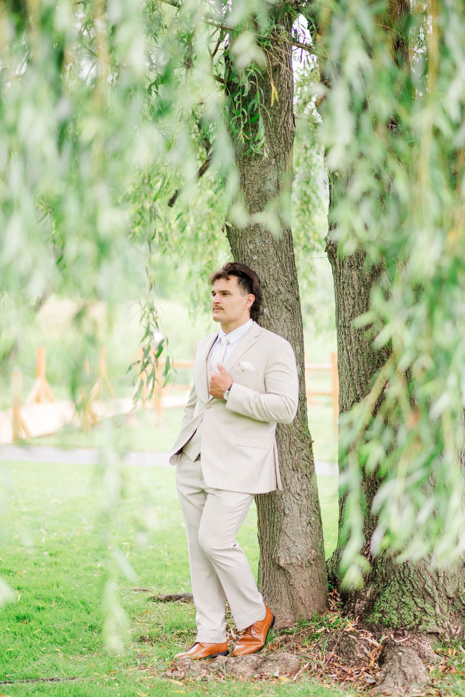 Groom under a willow tree at Whispering Hollow Estates in Pleasantville, Pennsylvania