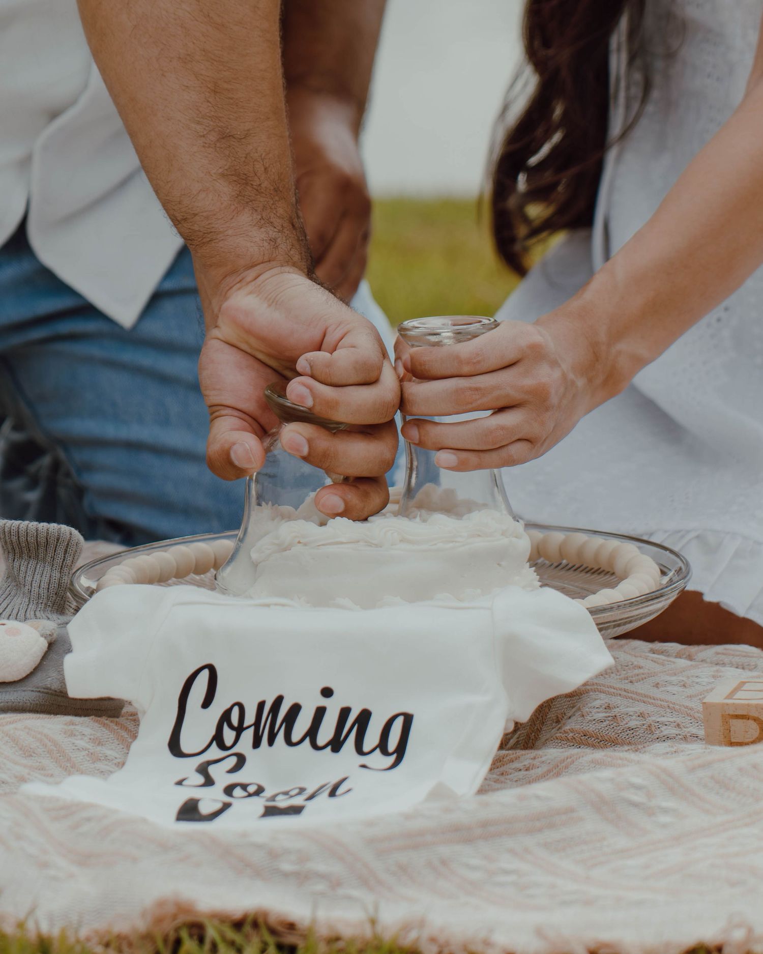 Couple holding a mason jar over a flour-filled bowl with a Coming Soon pregnancy announcement sign.