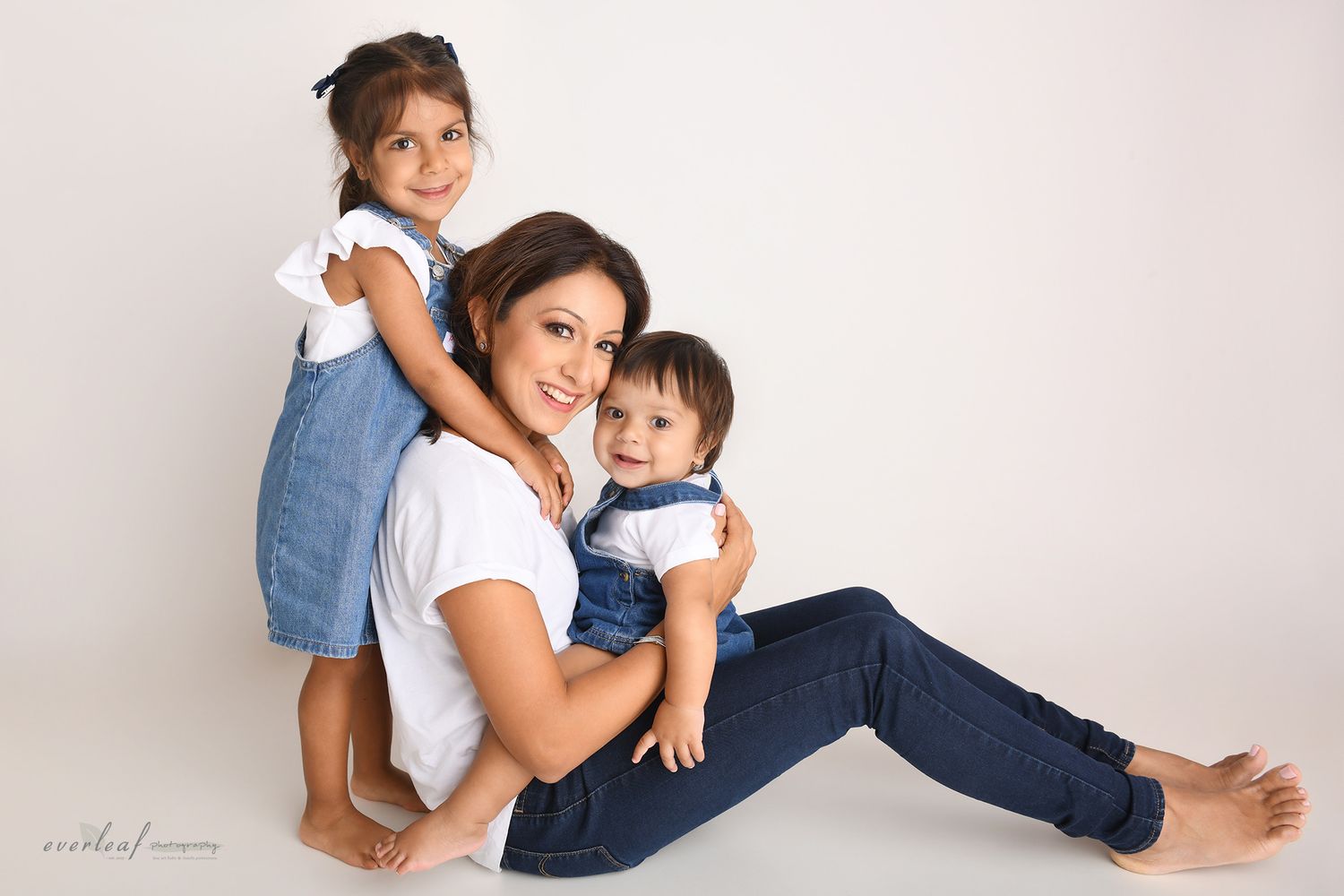 Mother smiling with her two young children during a family portrait