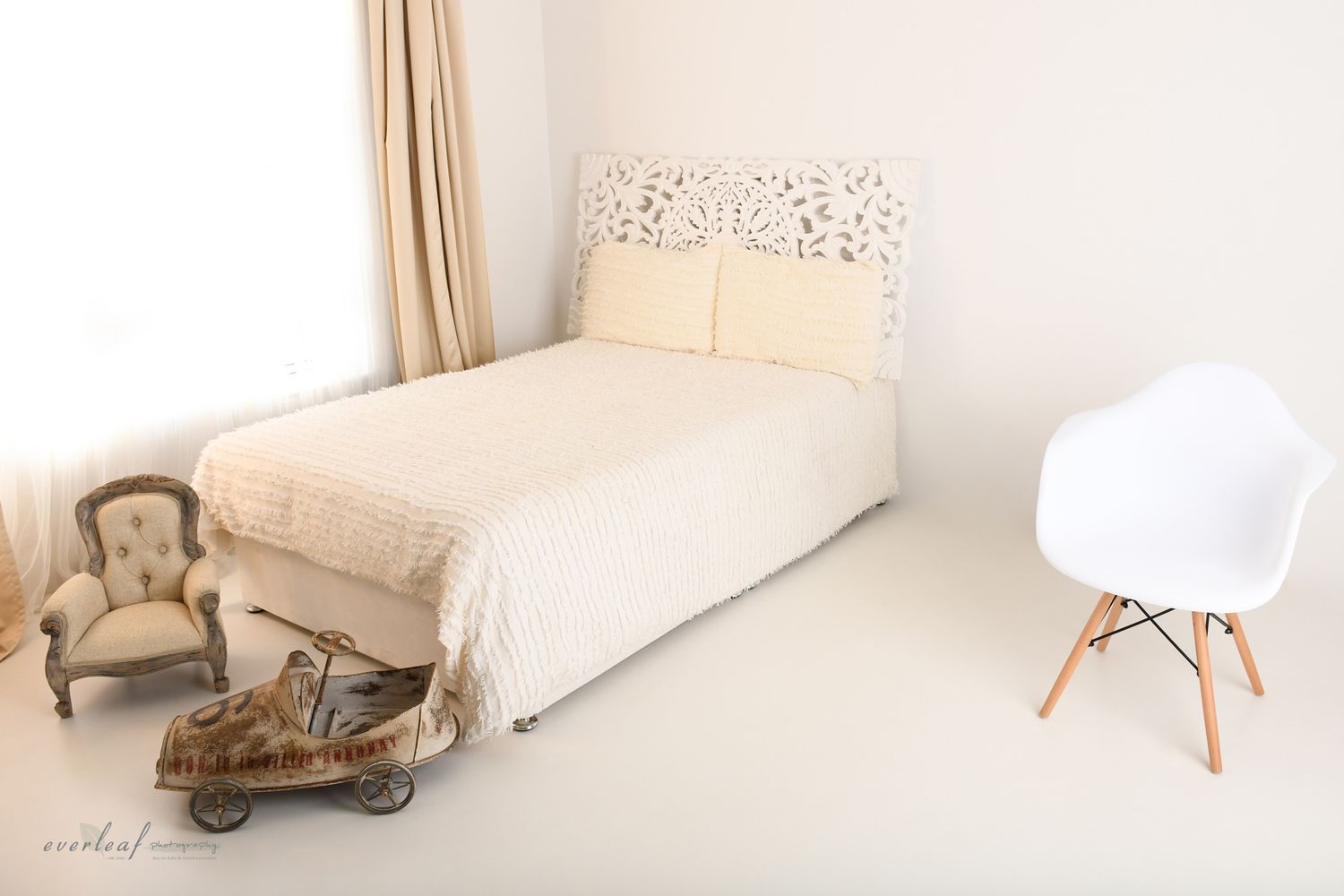 Everleaf Photography studio set with a bed, chair and vintage pram