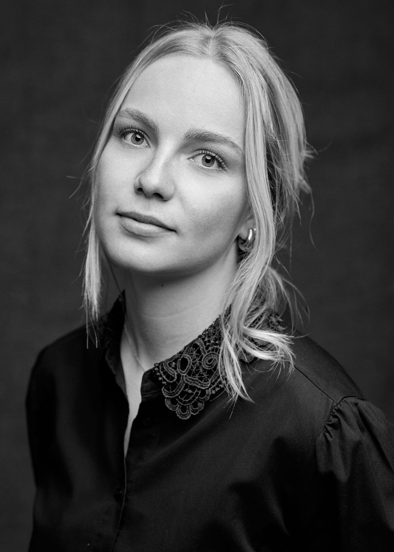 Portrait féminin en noir et blanc sur fond sombre