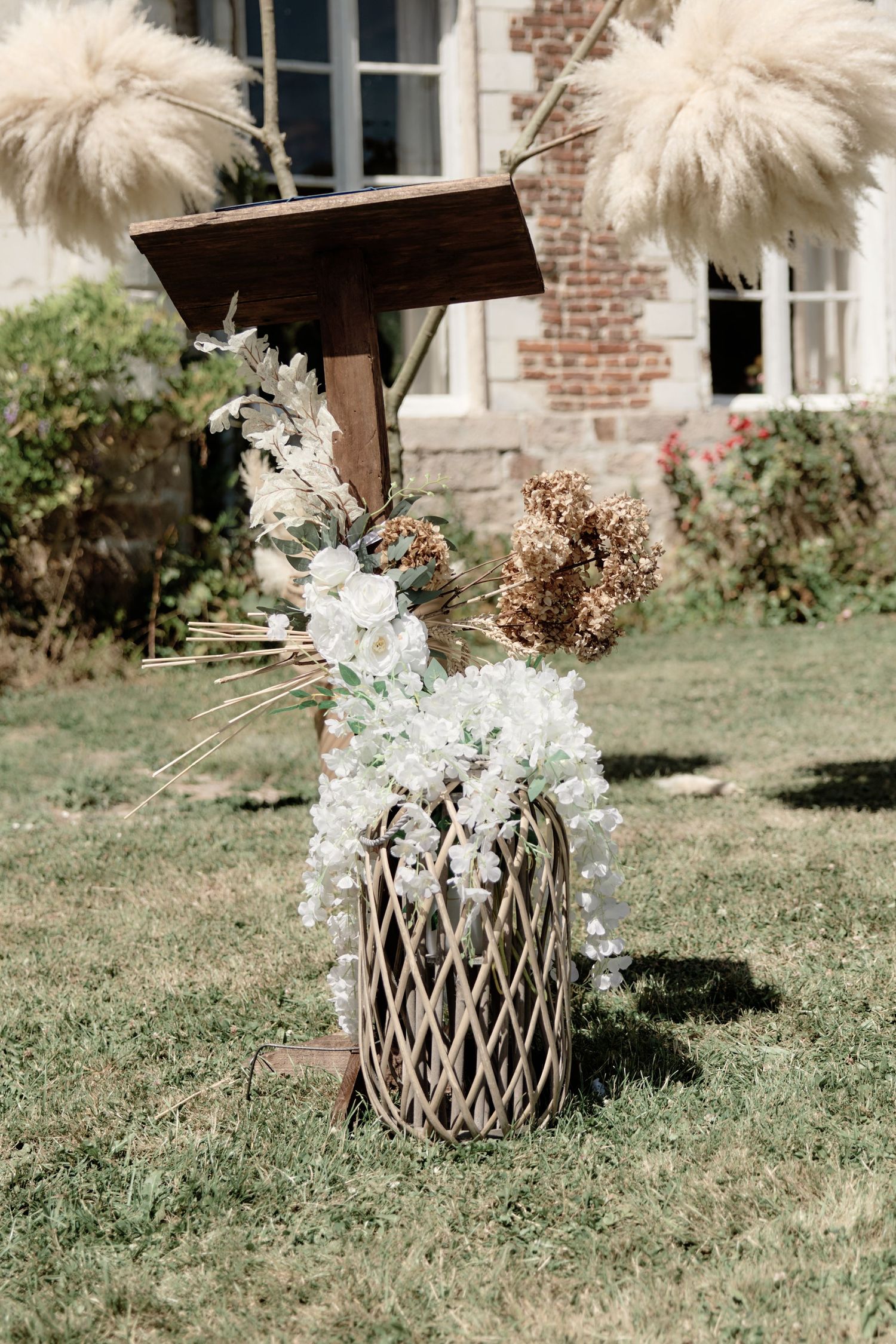 Composition florale de mariage installée dans le jardin du lieu de réception