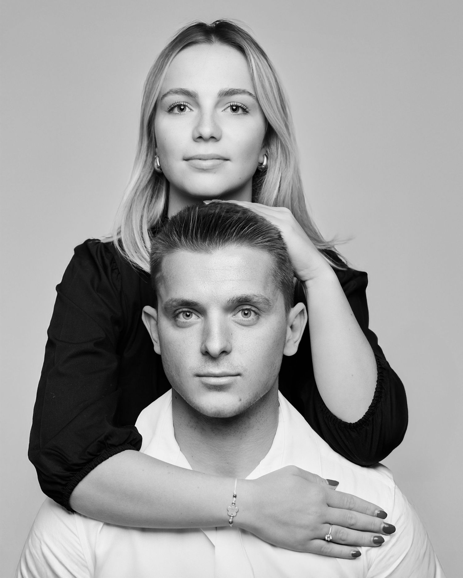 Portrait de couple en noir et blanc, femme derrière son partenaire