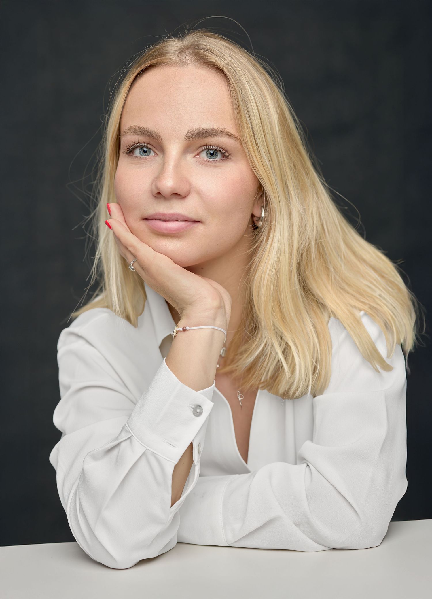 Portrait féminin en studio, le visage posé sur la main