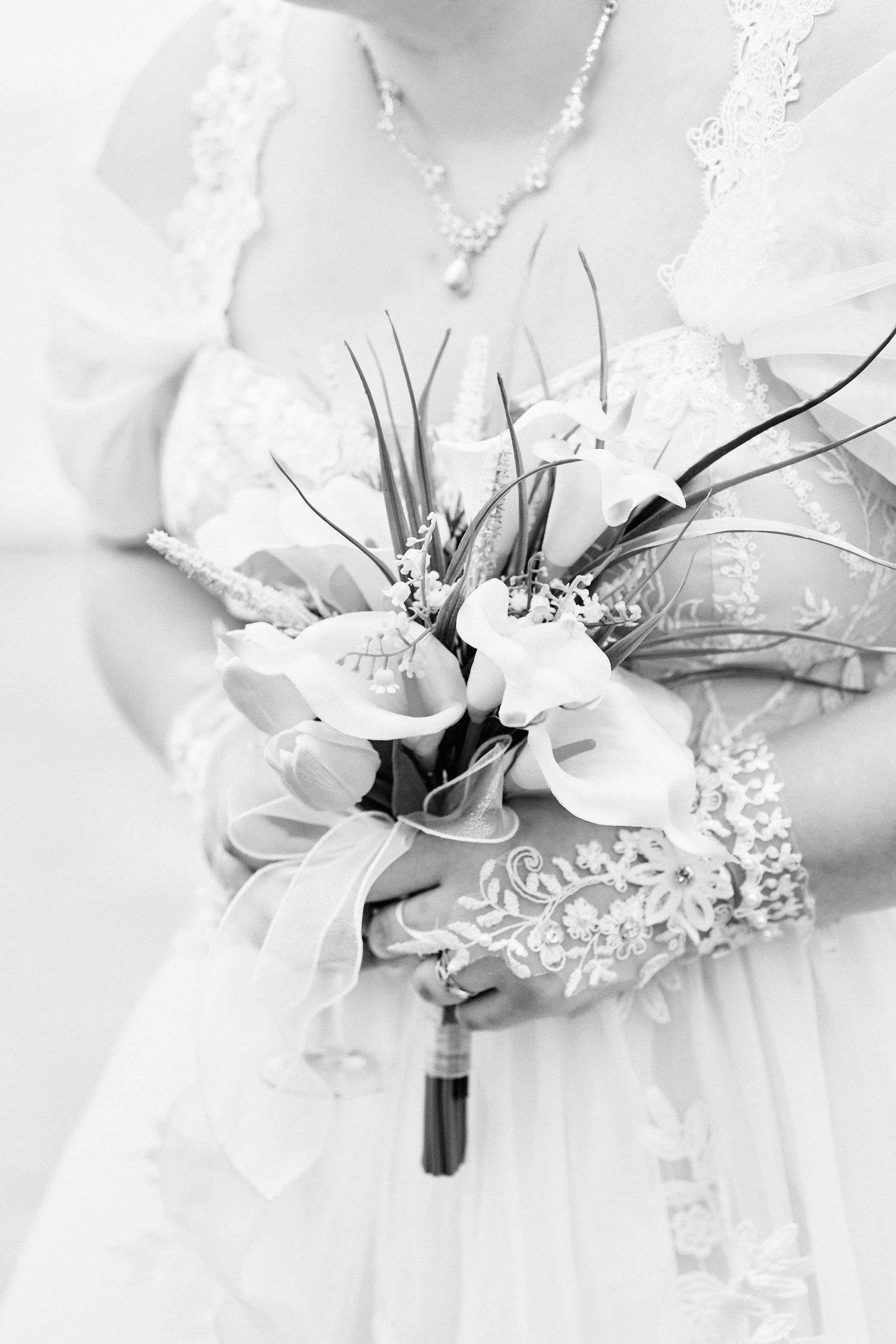 Bouquet de mariée tenu devant la robe en noir et blanc