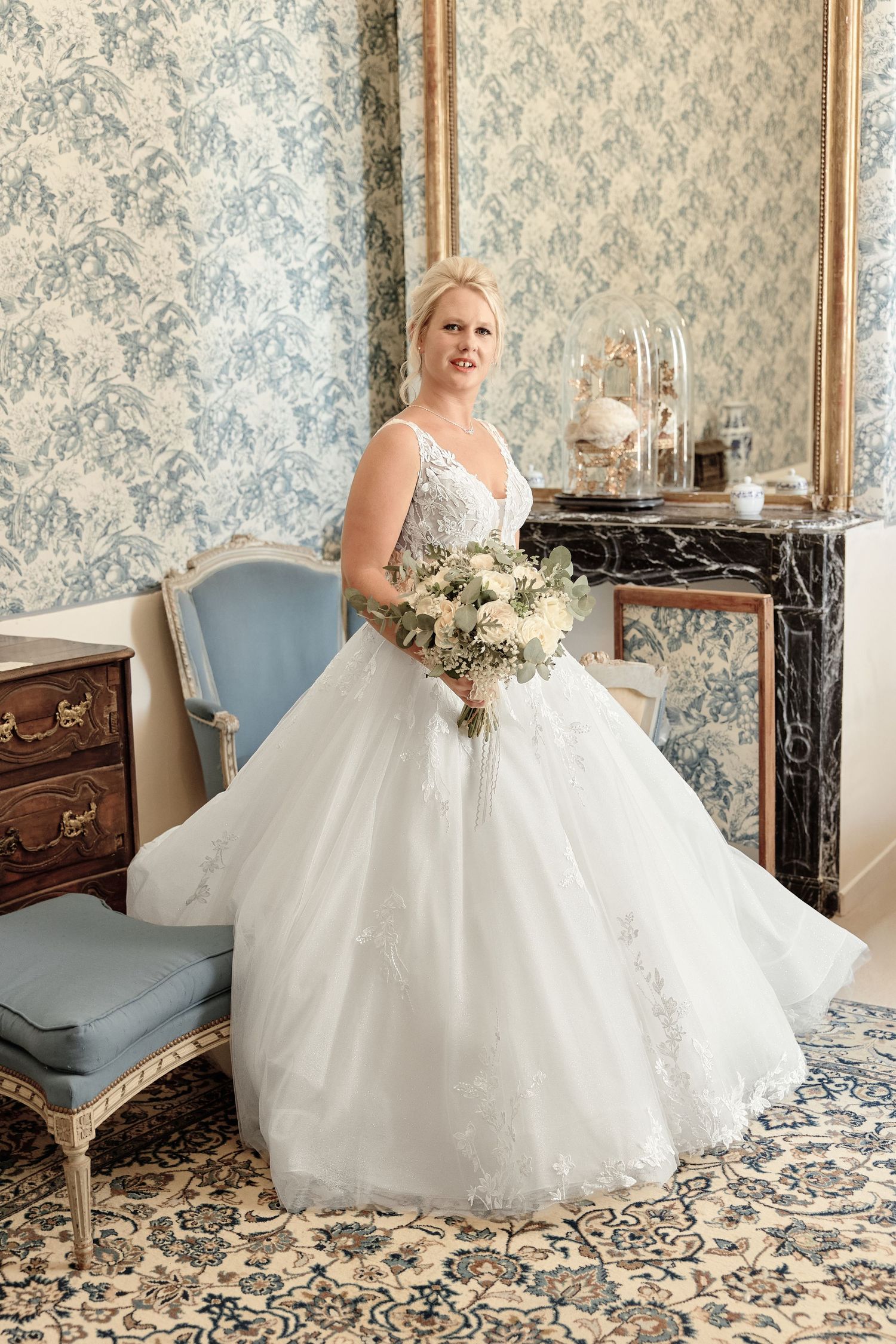 Mariée en robe blanche tenant son bouquet pendant les préparatifs