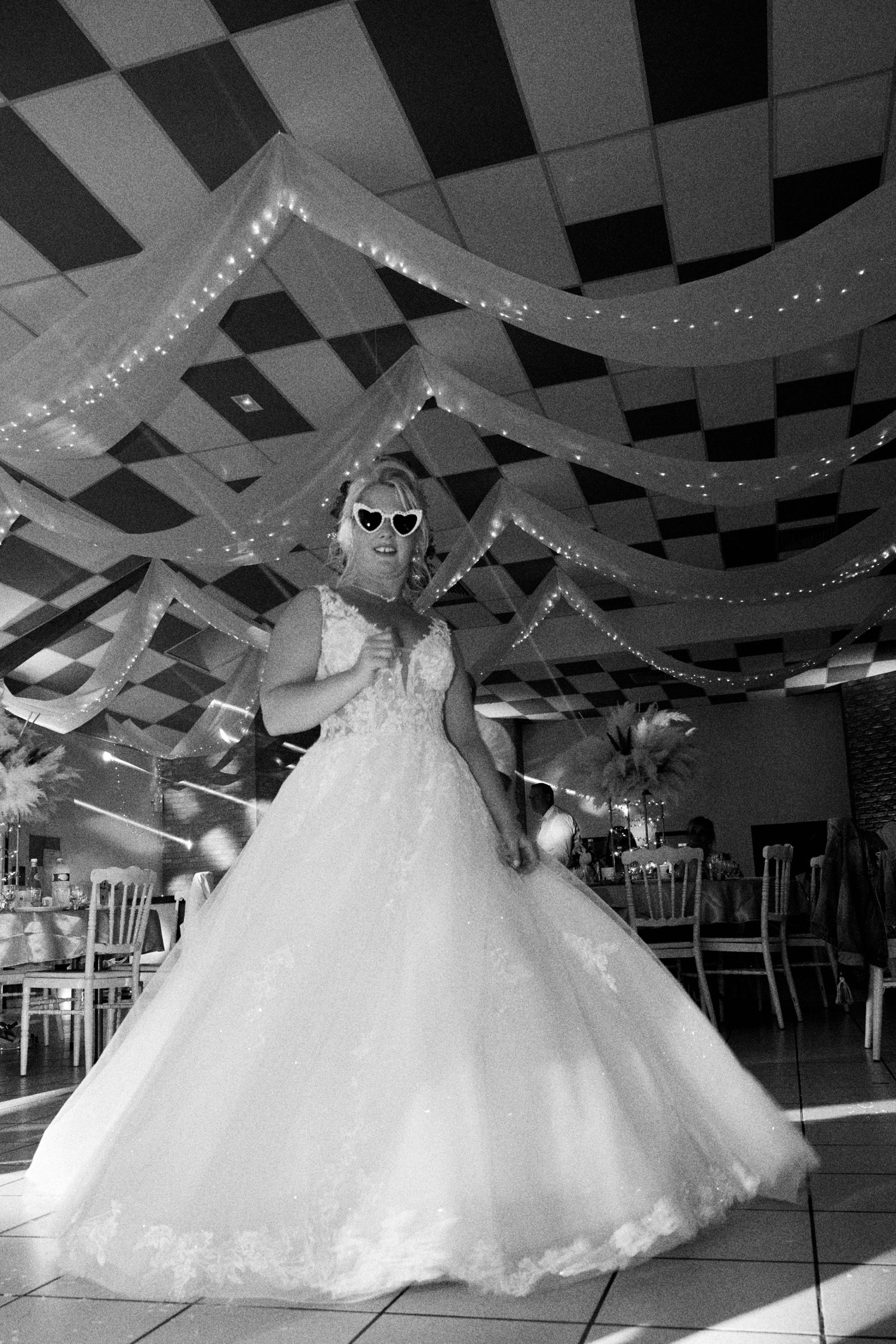 Mariée dansant pendant la soirée de mariage en noir et blanc
