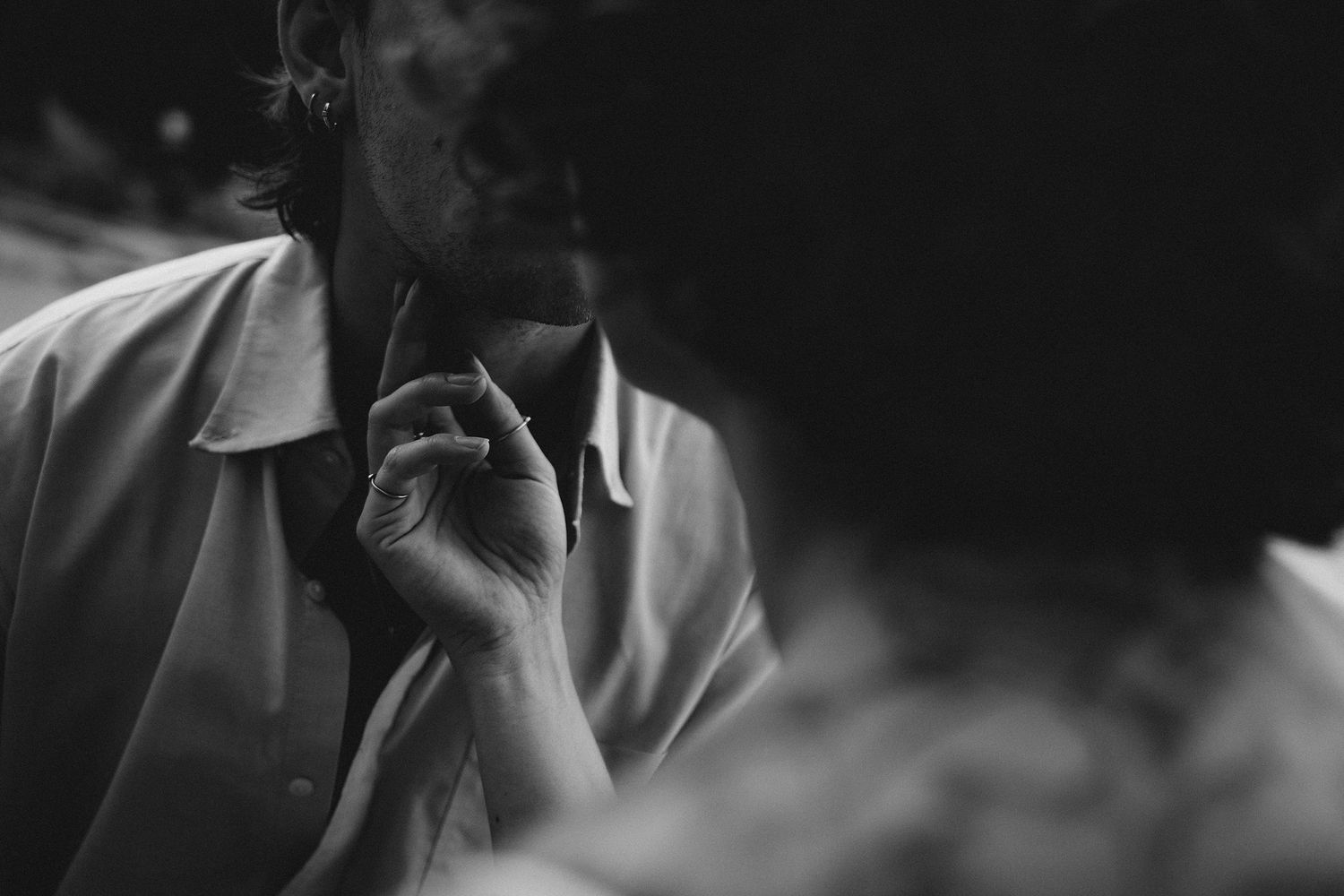 Black and white portrait of a bearded man smoking a cigarette in soft light.